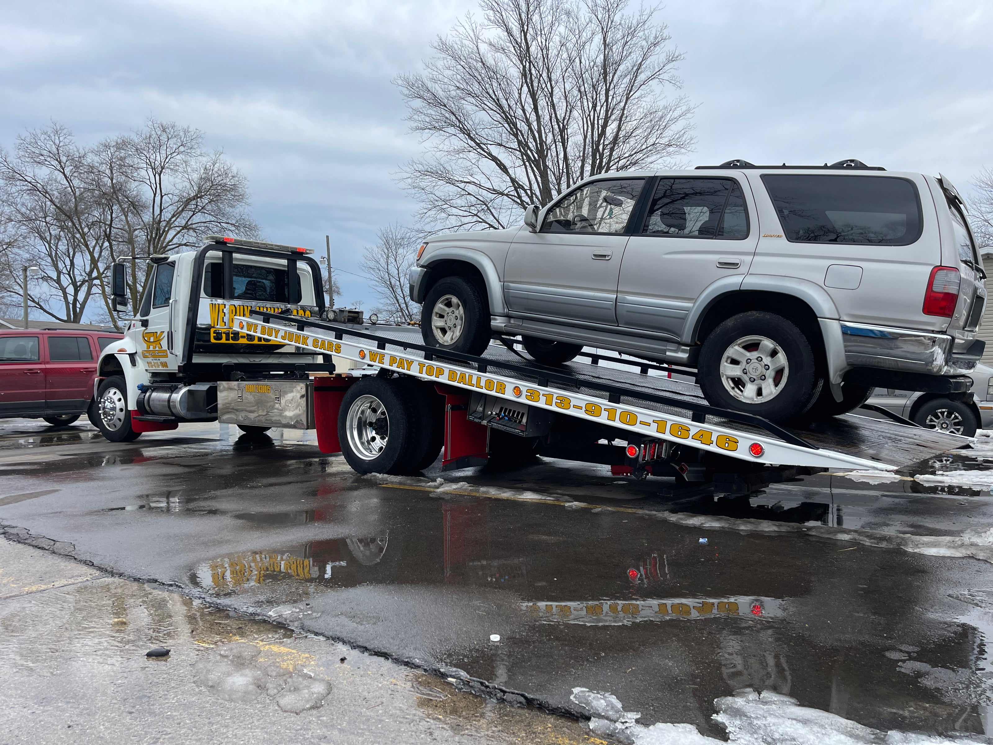 Grey car on junk car removal truck